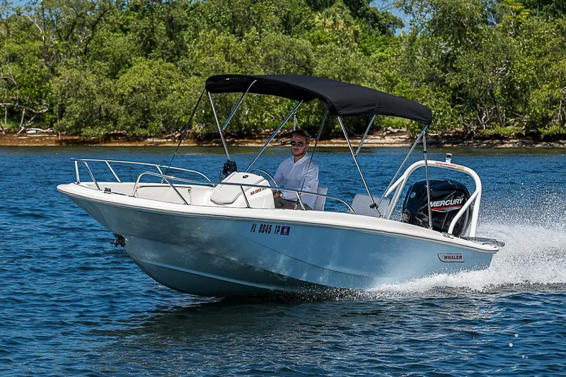 Slide: The Image of 2022 Boston Whaler 160 Super Sport boat cruising on a scenic lake. - 32
