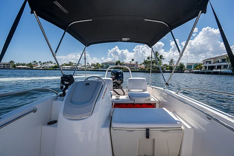 Slide: The Image of 2022 Boston Whaler 160 Super Sport boat interior on a sunny day, with waterfront view. - 2
