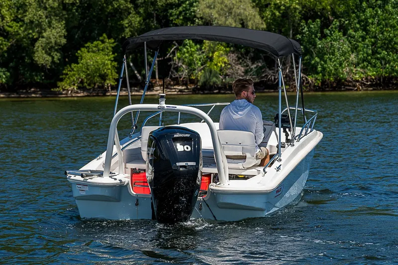Slide: The Image of 2022 Boston Whaler 160 Super Sport boat cruising on a scenic lake. - 16