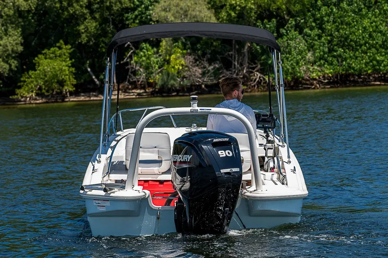 Slide: The Image of 2022 Boston Whaler 160 Super Sport boat cruising on a scenic waterway. - 15