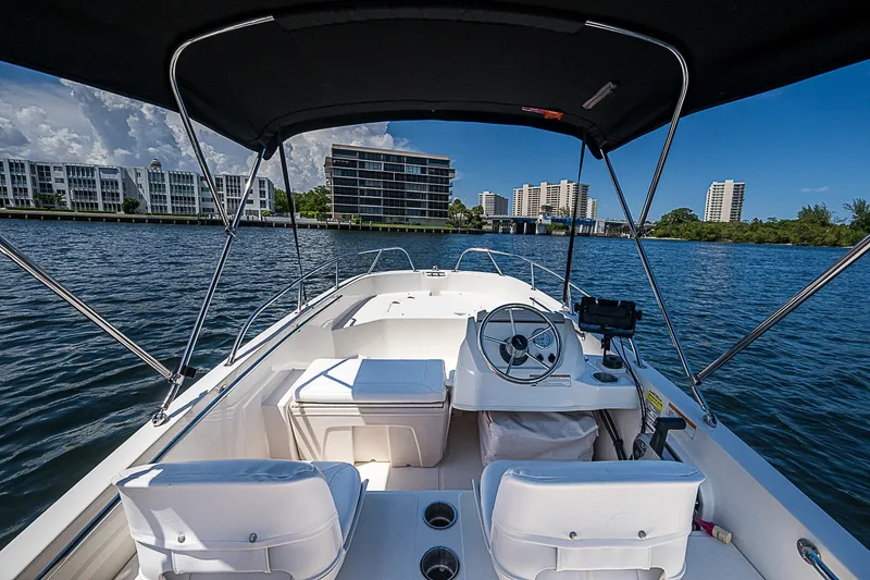 Slide: The Image of 2022 Boston Whaler 160 Super Sport boat on water, cityscape in background. - 6