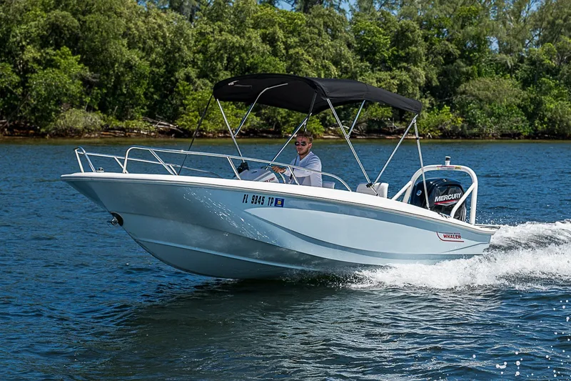 Slide: The Image of 2022 Boston Whaler 160 Super Sport boat cruising on a scenic lake. - 30