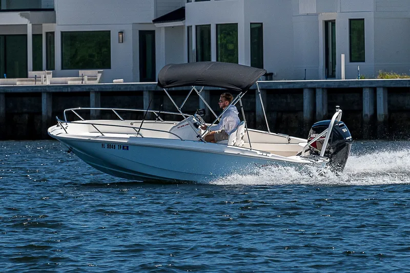 Slide: The Image of 2022 Boston Whaler 160 Super Sport cruising on water near modern waterfront homes. - 37