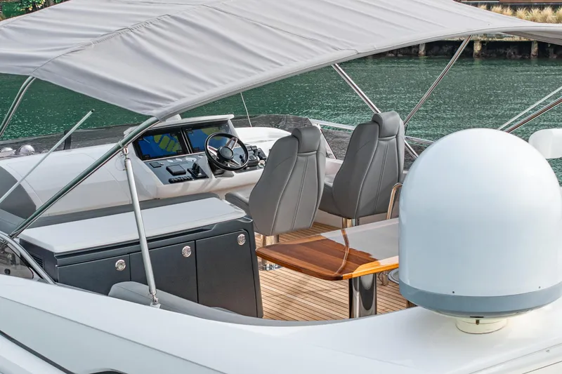 Slide: The Image of Luxury 2017 Princess S65 yacht cockpit with canopy, featuring modern seating and navigation controls. - 42
