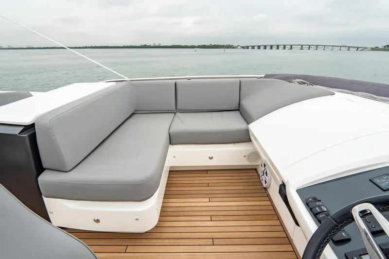 Slide: The Image of 2017 Princess S65 yacht with gray seating and wooden deck, overlooking calm waters. - 38