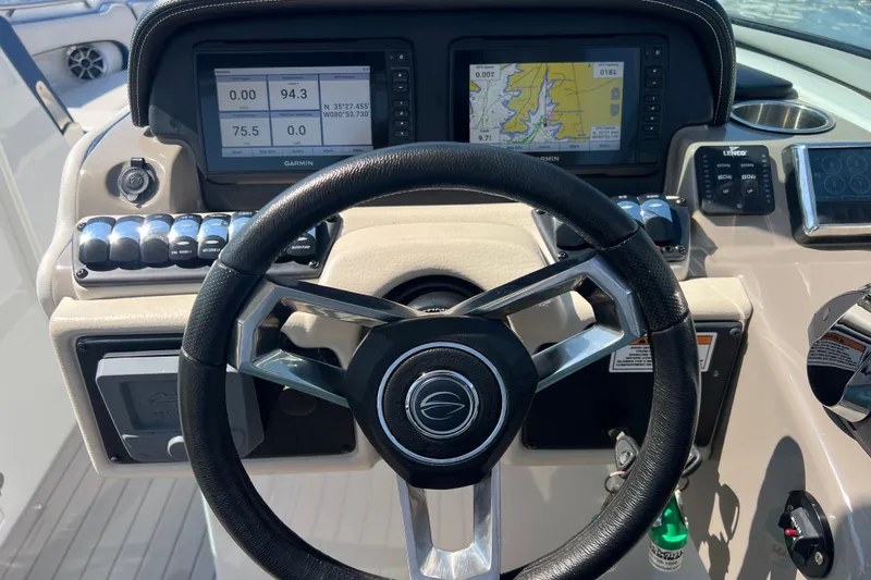 Slide: The Image of Steering wheel and dashboard of 2022 Crownline Eclipse E305 XS boat with navigation displays. - 28