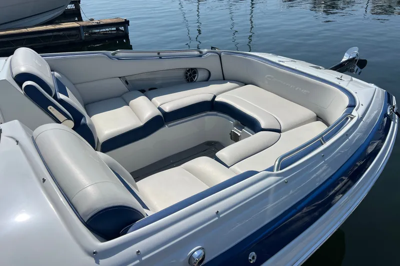 Slide: The Image of 2022 Crownline Eclipse E305 XS boat with spacious seating, docked on calm water. - 18