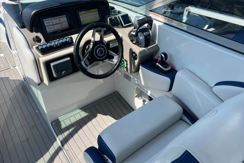 Slide: The Image of 2022 Crownline Eclipse E305 XS boat cockpit with steering wheel and control panel. - 21