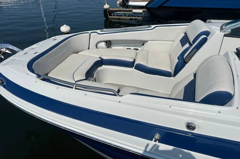 Slide: The Image of 2022 Crownline Eclipse E305 XS boat with luxurious white and blue seating, docked on calm water. - 12