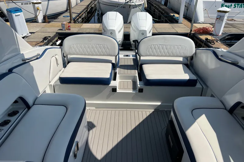 Slide: The Image of 2022 Crownline Eclipse E305 XS boat interior with white seating and dual engines. - 33