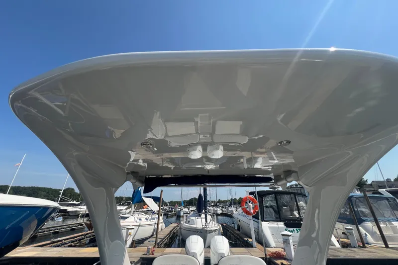 Slide: The Image of 2022 Crownline Eclipse E305 XS boat canopy view at marina under clear blue sky. - 31