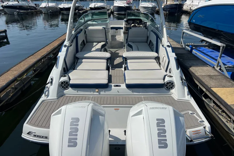 Slide: The Image of 2022 Crownline Eclipse E305 XS boat with spacious seating at a marina dock. - 13
