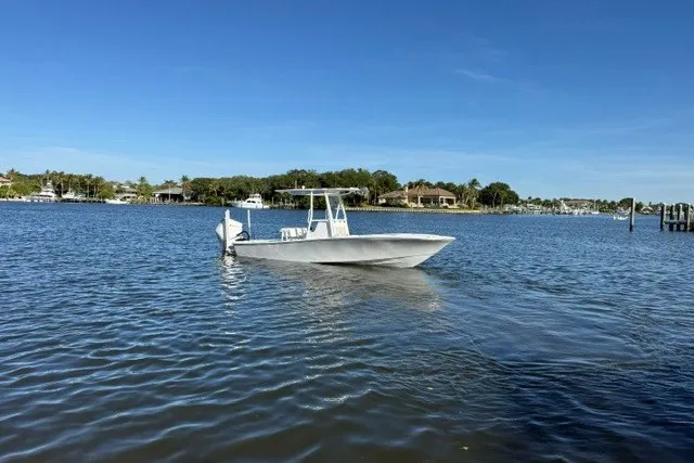 Slide: The Image of 2027 Conch 25 boat on calm water under clear blue sky. - 1