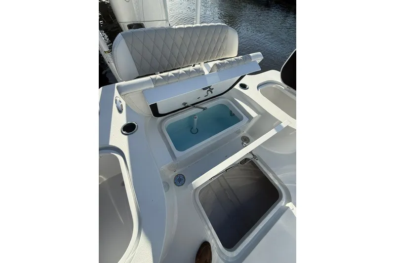 Slide: The Image of 2027 Conch 25 boat interior with open storage compartments and cushioned seating. - 6