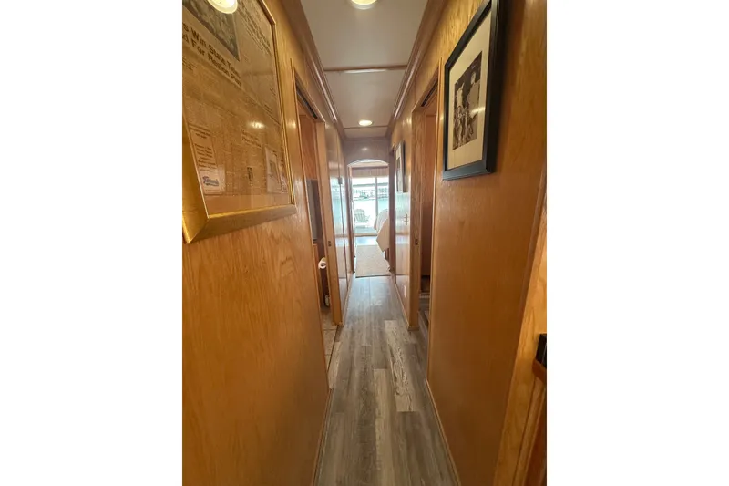 Slide: The Image of Narrow hallway in 2004 Lakeview 16x68 houseboat with wood paneling and framed pictures. - 6