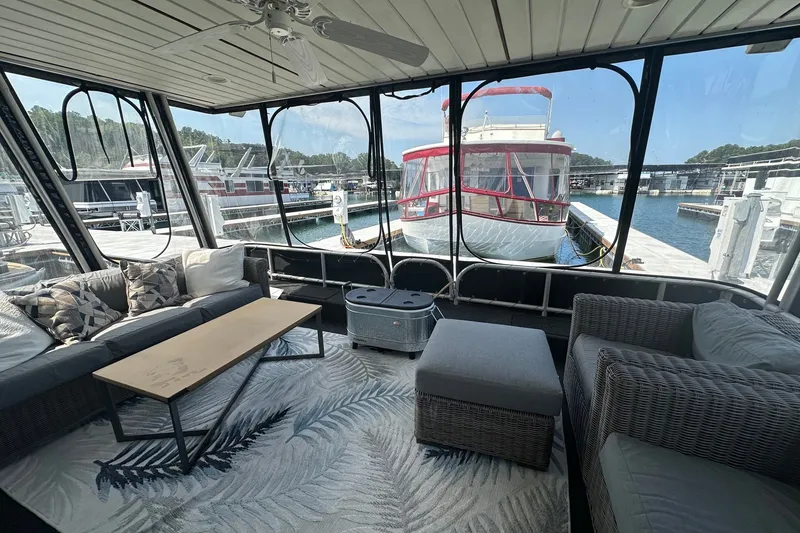 Slide: The Image of Houseboat interior with wicker furniture, large windows, and marina view. Lakeview 16x68, 2004 model. - 1