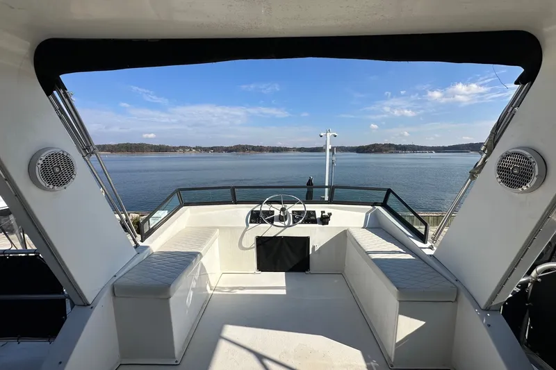 Slide: The Image of Helm view from 2004 Lakeview 16x68 houseboat overlooking serene lake and distant shoreline. - 14