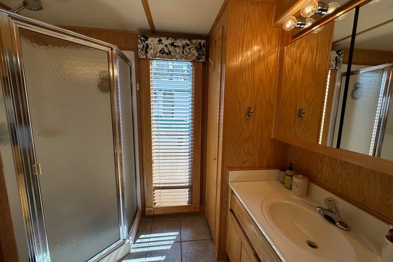 Slide: The Image of Bathroom in 2004 Lakeview model, featuring wood cabinetry, shower, and natural light. - 12