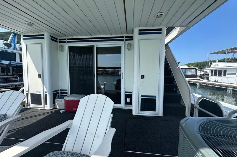 Slide: The Image of Houseboat deck with white chairs, sliding doors, and stairs; Lakeview 16x68, 2004 model. - 13
