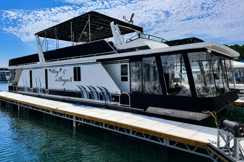 The Image of 2004 Lakeview 16x68 houseboat docked on a sunny day with clear skies. - 0