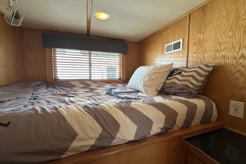 Slide: The Image of Cozy bedroom in 2004 Lakeview 16x68 houseboat with wood paneling and chevron bedding. - 7