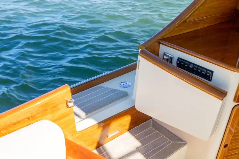 Slide: The Image of 2014 Hinckley Talaria 48 Flybridge deck with wood finish and control panel. - 74