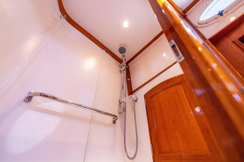 Slide: The Image of Shower area in 2014 Hinckley Talaria 48 Flybridge yacht with wooden accents and chrome fixtures. - 47
