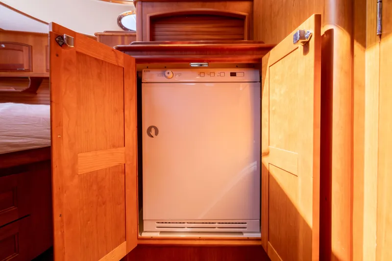 Slide: The Image of 2014 Hinckley Talaria 48 Flybridge interior with built-in dishwasher in wooden cabinetry. - 43