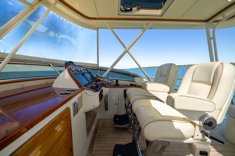 Slide: The Image of Flybridge interior of 2014 Hinckley Talaria 48, featuring luxurious seating and navigation controls. - 54