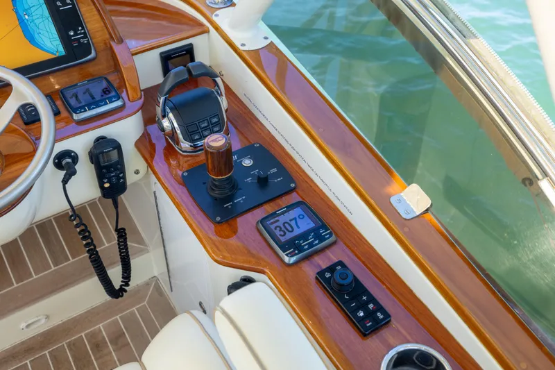 Slide: The Image of Helm controls of 2014 Hinckley Talaria 48 Flybridge with navigation equipment and wooden accents. - 65