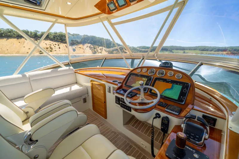 Slide: The Image of 2014 Hinckley Talaria 48 Flybridge helm with luxurious seating and advanced navigation systems. - 57