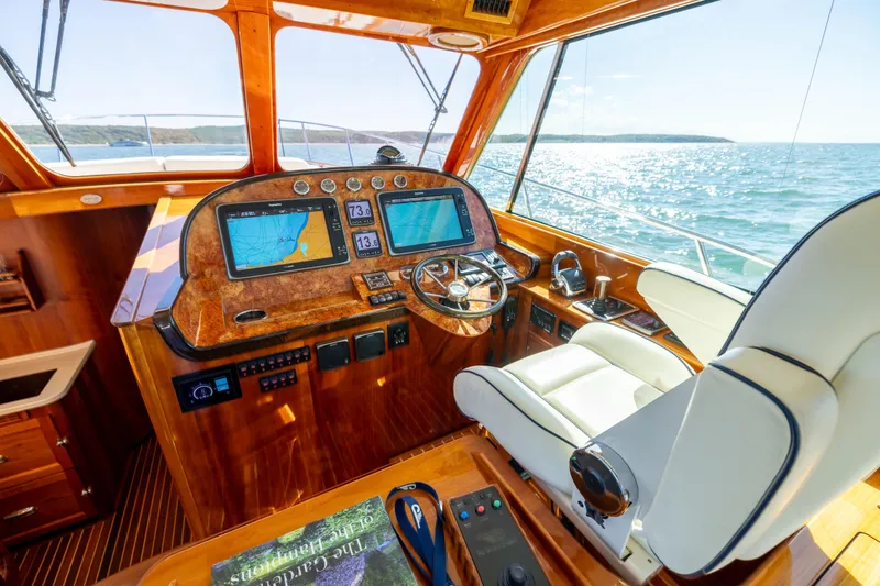 Slide: The Image of 2014 Hinckley Talaria 48 Flybridge helm with navigation screens and luxurious seating. - 25