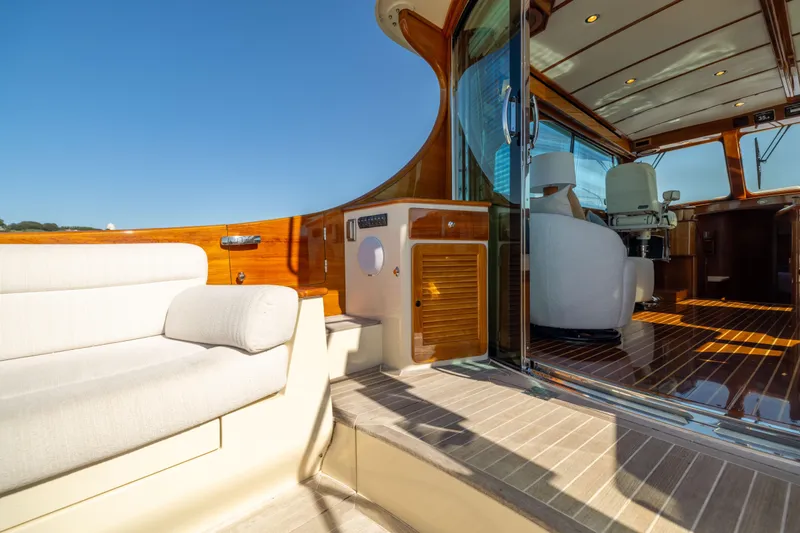 Slide: The Image of Luxurious 2014 Hinckley Talaria 48 Flybridge yacht interior with elegant seating and polished wood finishes. - 16