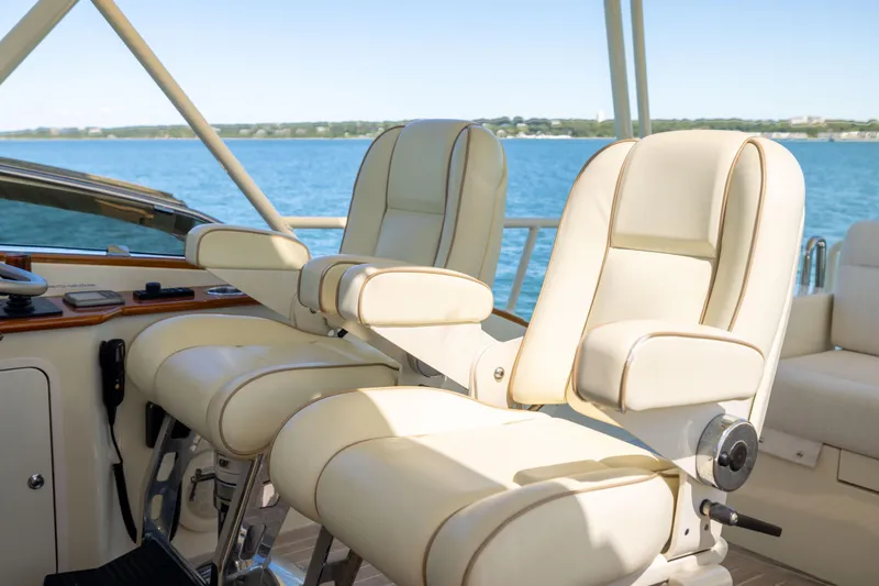 Slide: The Image of Luxurious helm seats on 2014 Hinckley Talaria 48 Flybridge yacht, overlooking serene waters. - 59
