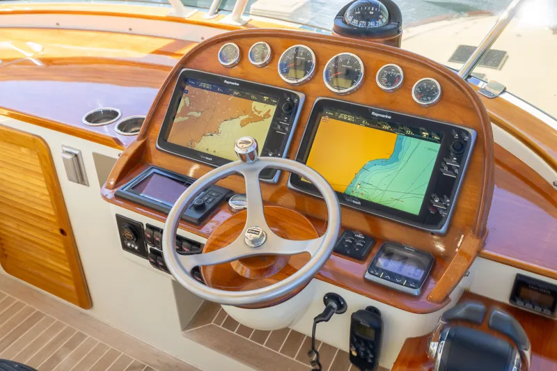 Slide: The Image of Helm of 2014 Hinckley Talaria 48 Flybridge with navigation screens and wooden finish. - 61