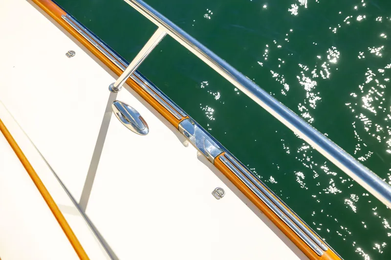 Slide: The Image of Hinckley Talaria 48 Flybridge 2014 yacht deck with polished railing over sparkling water. - 70