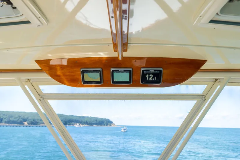 Slide: The Image of Hinckley Talaria 48 Flybridge 2014 dashboard with navigation screens, overlooking ocean view. - 64