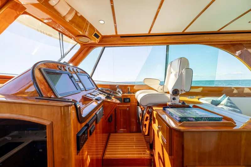 Slide: The Image of 2014 Hinckley Talaria 48 Flybridge helm with luxurious wood finish and modern navigation equipment. - 21