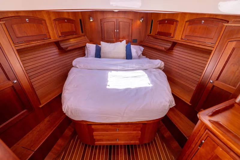 Slide: The Image of Luxurious 2014 Hinckley Talaria 48 Flybridge cabin with elegant wood finish and cozy bedding. - 41
