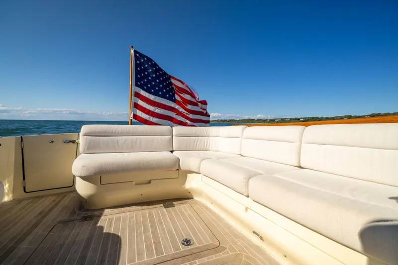 Slide: The Image of Hinckley Talaria 48 Flybridge 2014 yacht deck with American flag and white seating. - 14