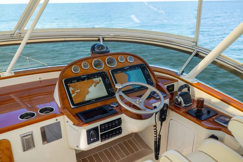 Slide: The Image of Helm of 2014 Hinckley Talaria 48 Flybridge with navigation screens and ocean view. - 62