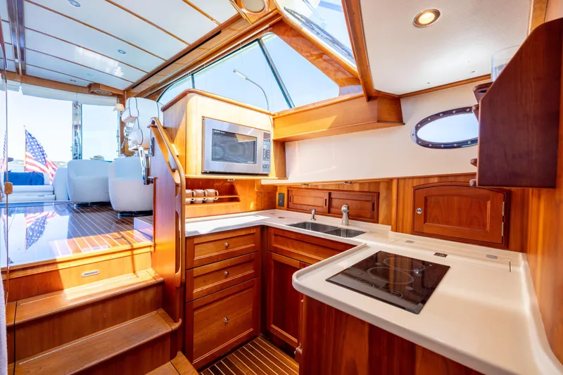 Slide: The Image of Luxurious 2014 Hinckley Talaria 48 Flybridge yacht interior with modern kitchen and wooden cabinetry. - 30