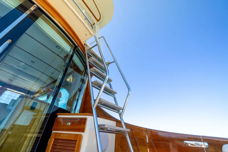 Slide: The Image of 2014 Hinckley Talaria 48 Flybridge yacht with stainless steel ladder and glass doors. - 49