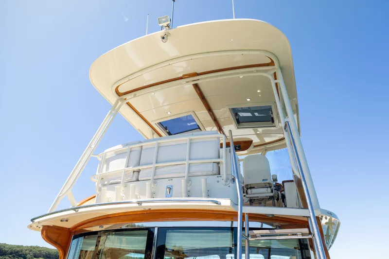 Slide: The Image of 2014 Hinckley Talaria 48 Flybridge yacht with sleek design under clear blue sky. - 50