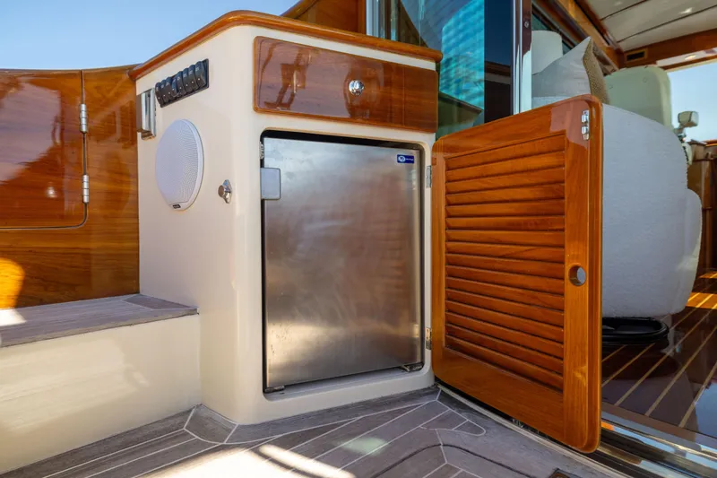 Slide: The Image of Hinckley Talaria 48 Flybridge 2014 yacht interior with wooden cabinetry and stainless steel fridge. - 17