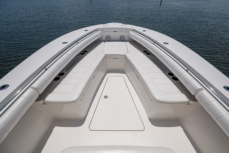 Slide: The Image of 2012 Regulator 28 Forward Seating boat with spacious white cushioned seating on calm water. - 10
