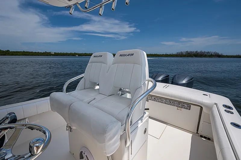 Slide: The Image of 2012 Regulator 28 Forward Seating boat with dual engines on a calm waterway. - 28