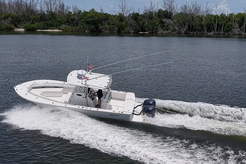 Slide: The Image of 2012 Regulator 28 Forward Seating boat cruising on a calm river with lush greenery. - 7