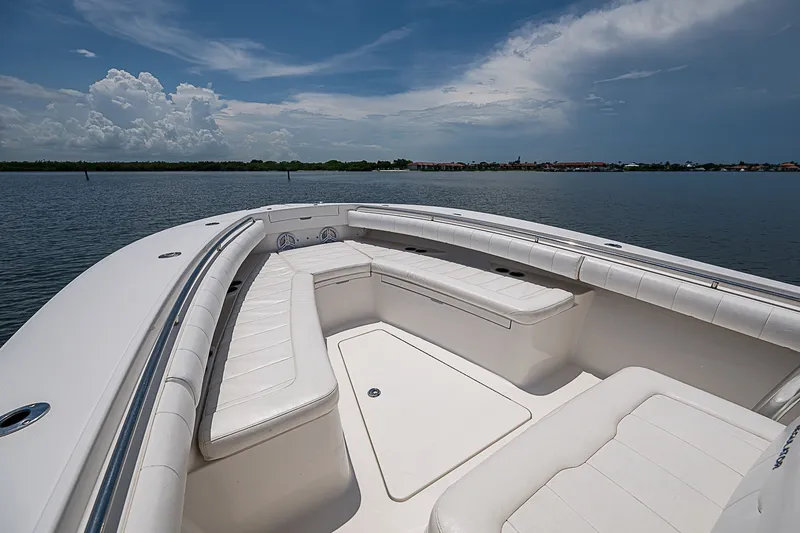 Slide: The Image of 2012 Regulator 28 Forward Seating boat on calm water under a cloudy sky. - 9
