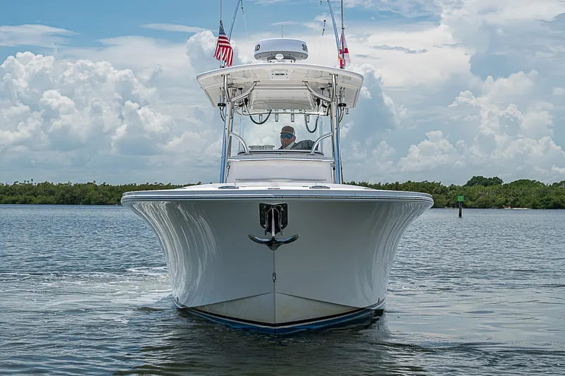 Slide: The Image of 2012 Regulator 28 Forward Seating boat cruising on a calm waterway under a cloudy sky. - 3